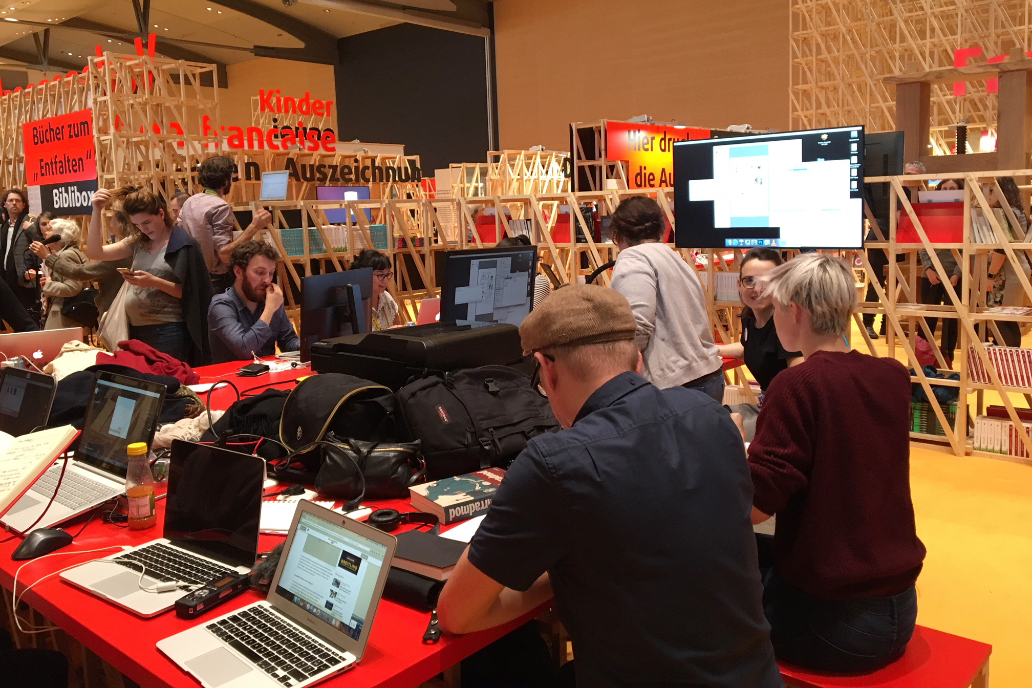 Mehrere Personen sitzen vor Laptops und Monitoren im französischen Pavillon der Buchmesse Frankfurt.